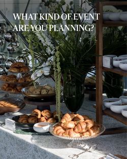 Buffet table with croissants, pastries, bowls, and a central floral arrangement at SUMMIT Events venue.
