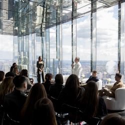 Corporate event in a Midtown event space with floor-to-ceiling glass windows offering panoramic NYC views.