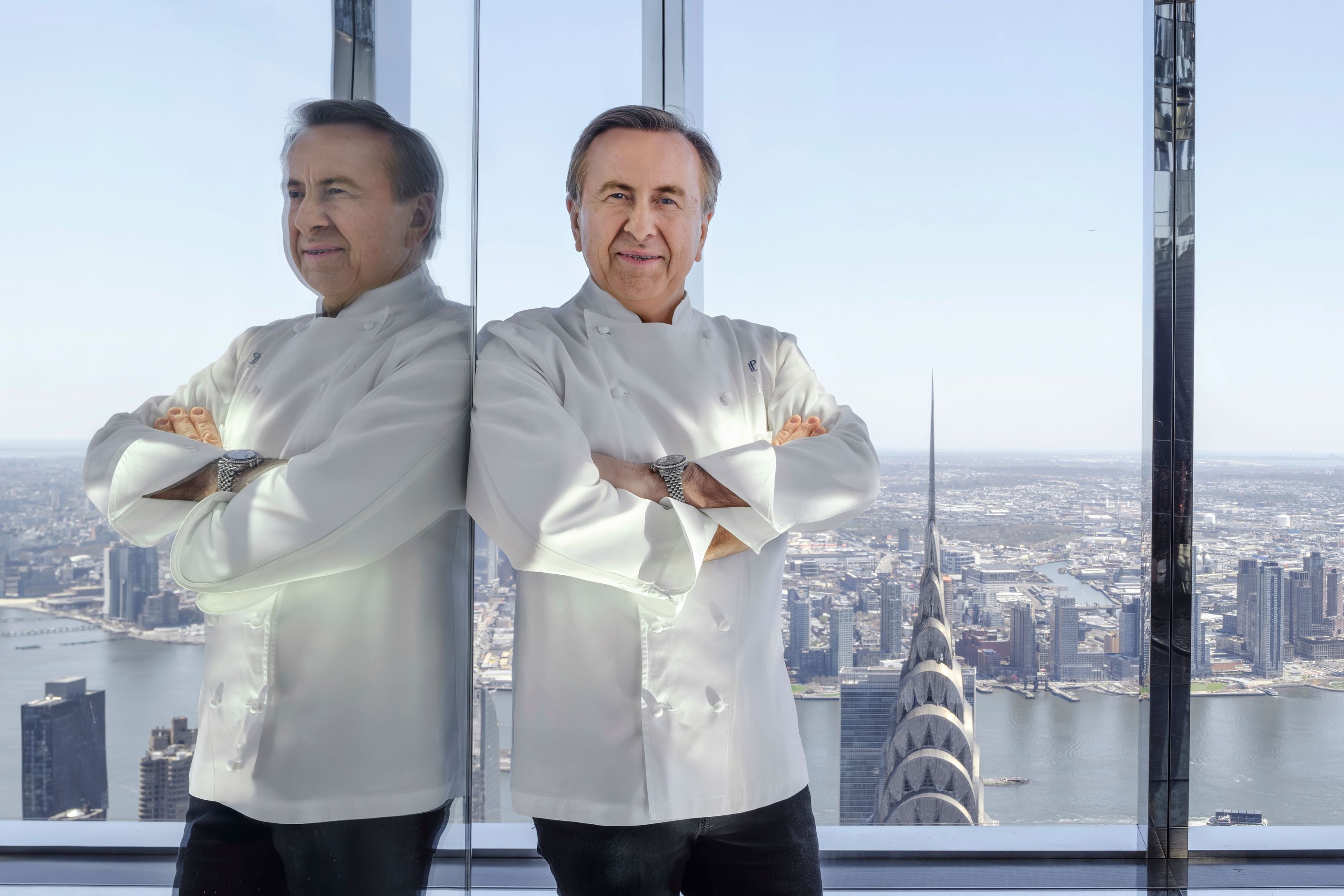 Renowned chef poses in front of panoramic NYC skyline, showcasing stunning views from Summit Events.