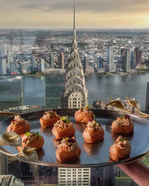 Gourmet appetizers on a tray overlooking the NYC skyline, showcasing an upscale event space in the heart of the city.